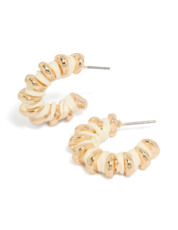 Statement hoop earrings featuring gold ribbed detailing with ivory yarn wrapping and round accents front view