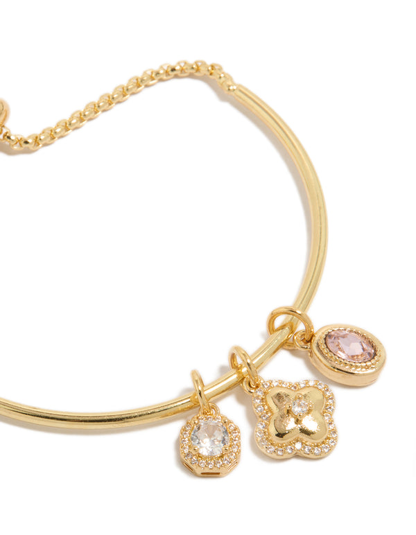 Elegantly designed gold plated cubic zirconia and flower charms toggle bangle featuring oval stone with crystal details close up view
