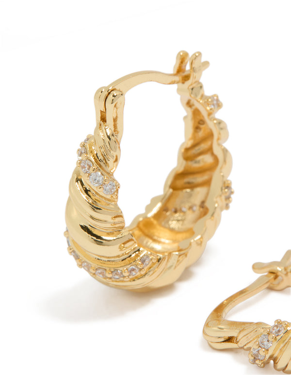 Detailed view of gold plated twist huggie earrings with cubic zirconia close up view