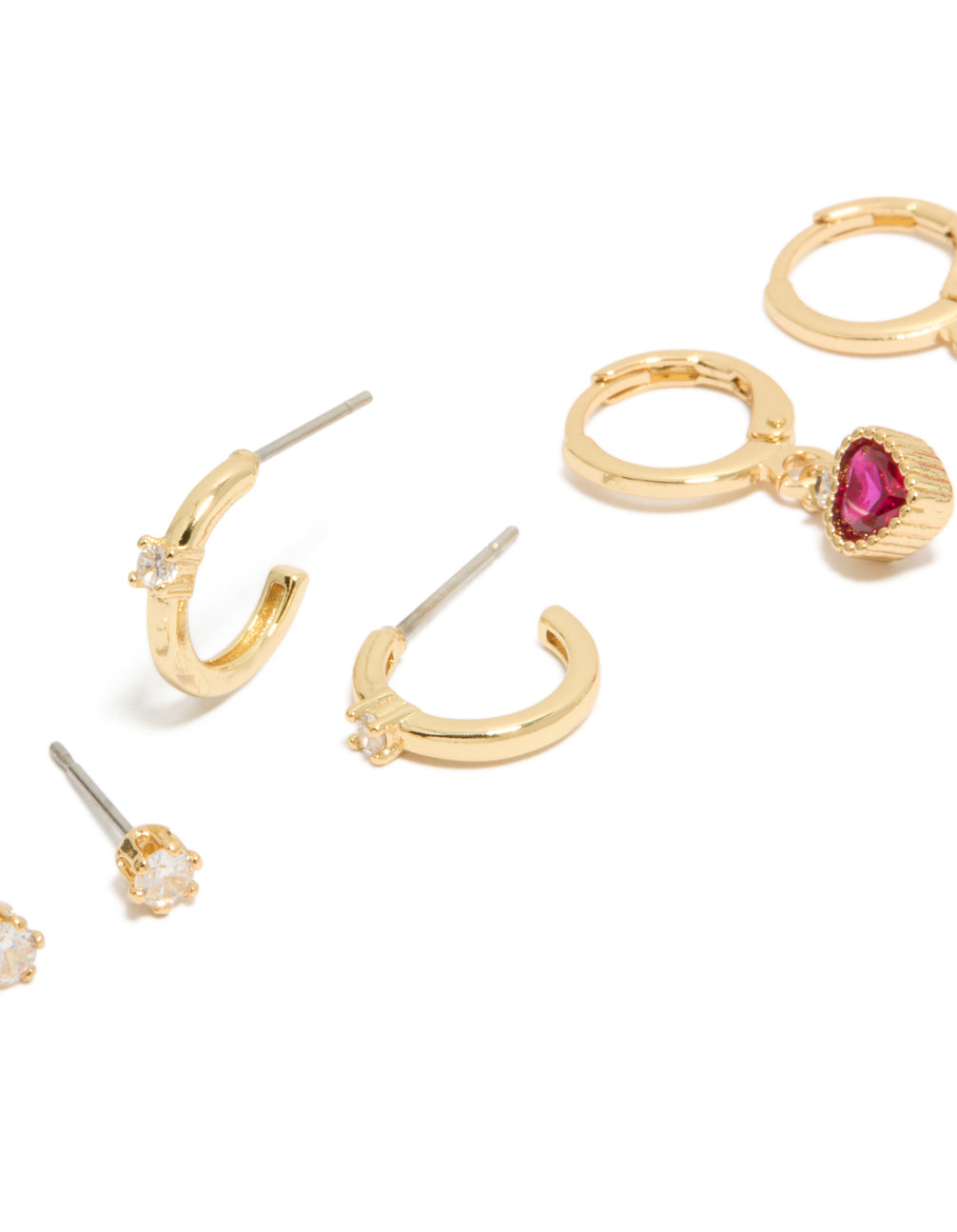 Crafted from gold plated material, cubic zirconia studs and heart huggie earrings in a 3-pack with charm details, crystal embellishments close up view
