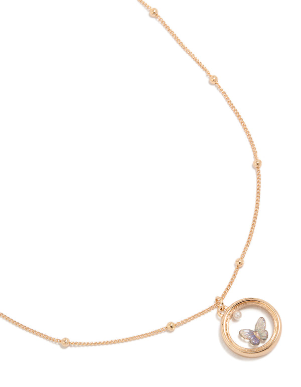Elegant butterfly in circle pendant necklace featuring balls, pearl and gold accents close up view