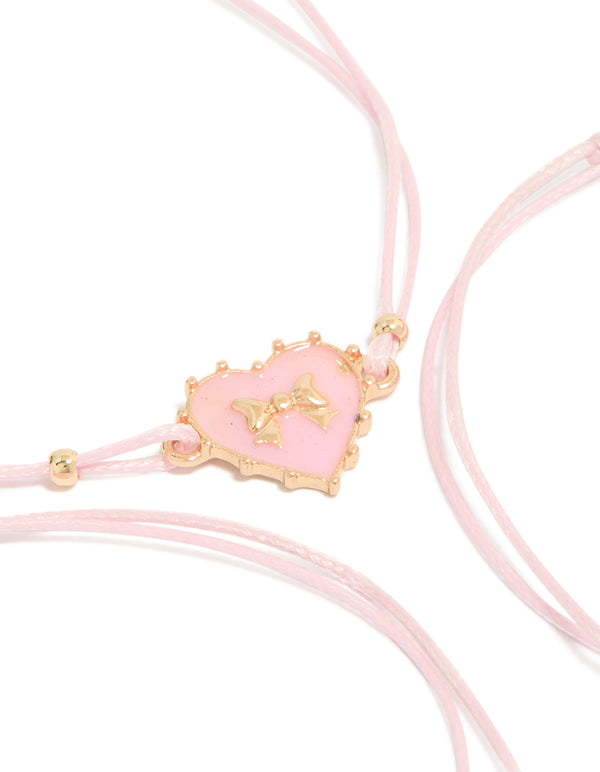 Showcasing heart charm bracelets crafted from cord and enamel in a 3-pack with light pink and gold tones close up view