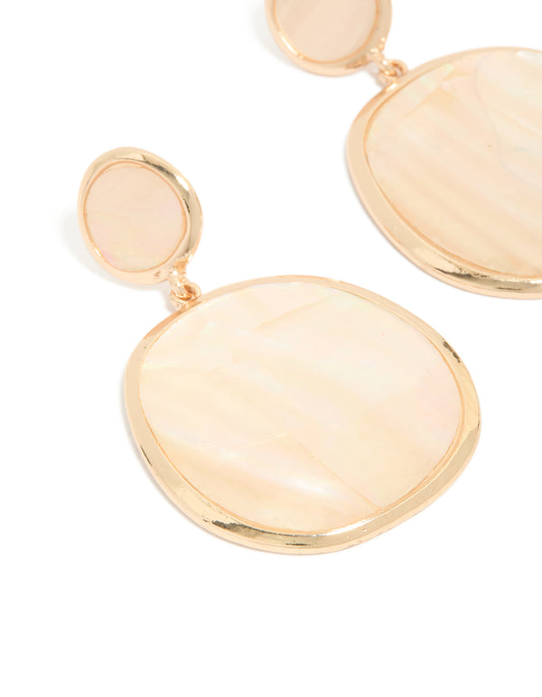 Crafted from shell, these statement drop earrings showcase pink and gold tones with ocean elements close up view