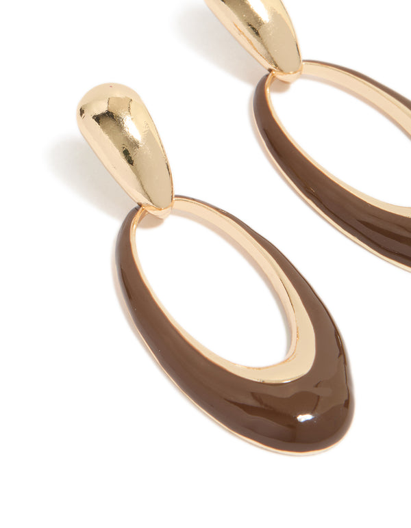 Featuring statement oval drop earrings with brown enamel in gold close up view