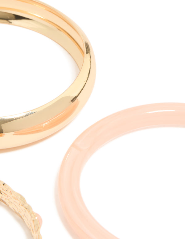 Featuring chunky gold textured and resin bangles in a 3-pack with peachpuff accents close up view