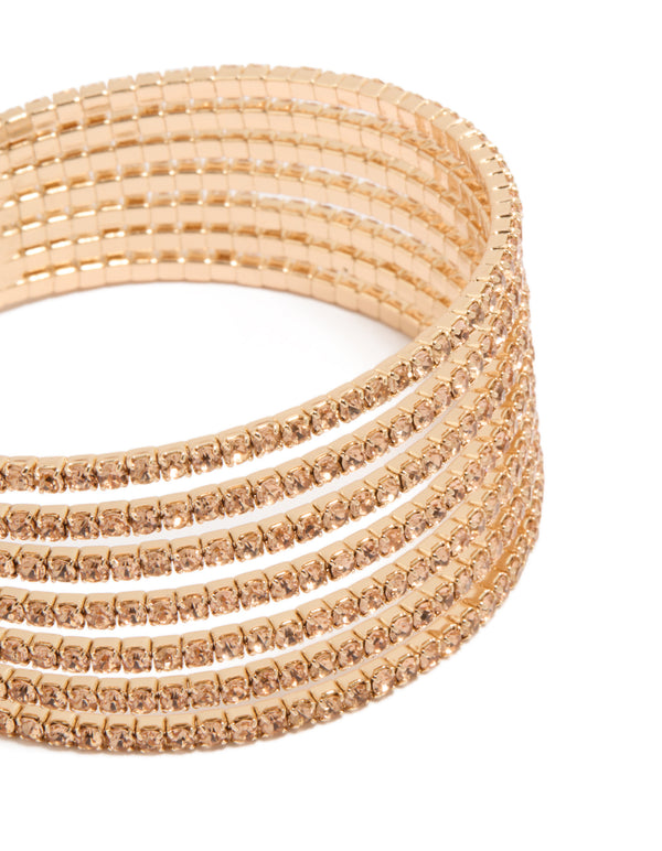 Highlighting a gold diamante layered wrist cuff featuring a statement bangle design in tan close up view