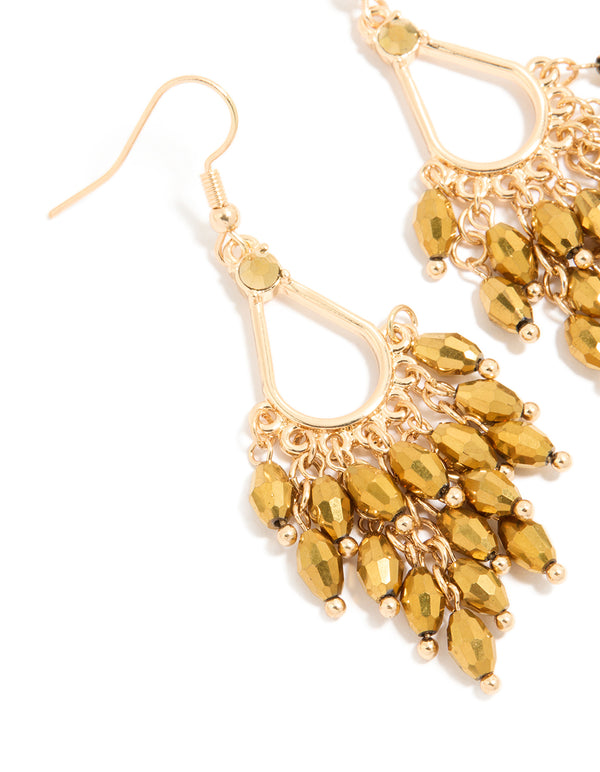 Highlighting statement drop earrings with irregular beaded charms in gold close up view