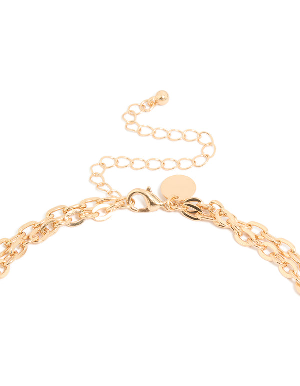 Close-up of genuine shell, ocean and disc layered necklace showcasing statement gold clasp detail view