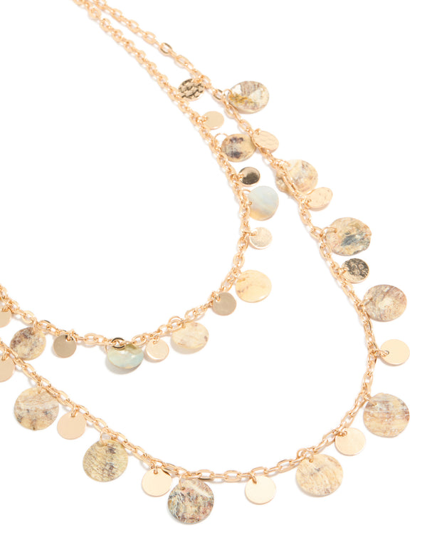 Beautifully layered necklace featuring genuine shell charms with ocean-inspired discs in statement gold close up view