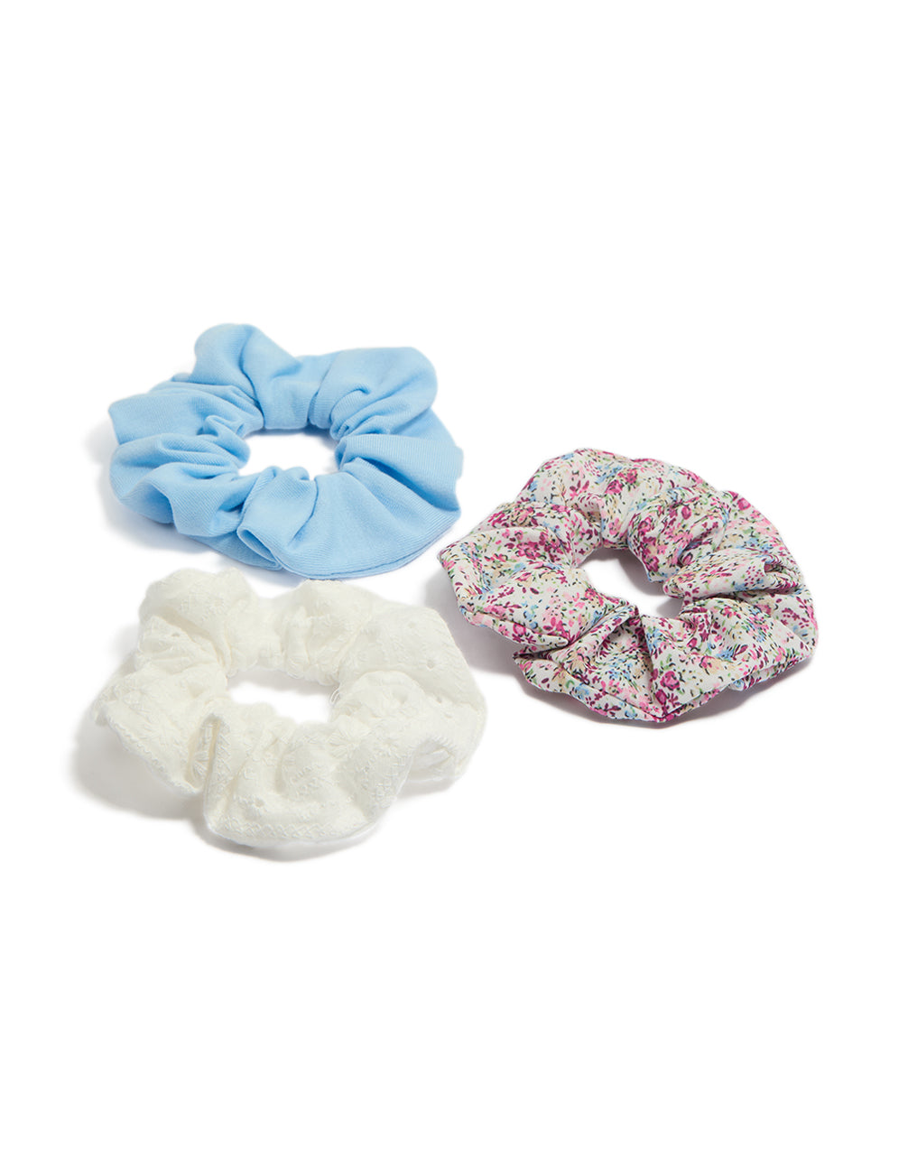 Showcasing kids floral print and broderie fabric scrunchies in a 3-pack featuring light blue, white, pink, and light green front view