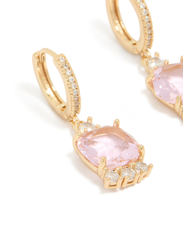 Highlighting gold pink cubic zirconia square huggie earrings in statement style with clear accents close up view