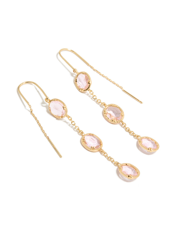 Showcasing statement earrings crafted from gold plated material with oval cut pink diamantes in a thread through design front view