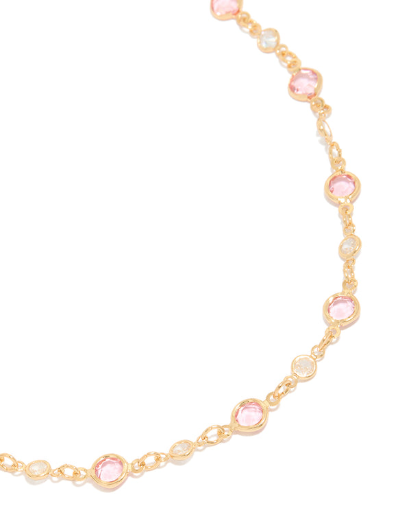 Showcasing a gold pink and clear cubic zirconias round station necklace close up view