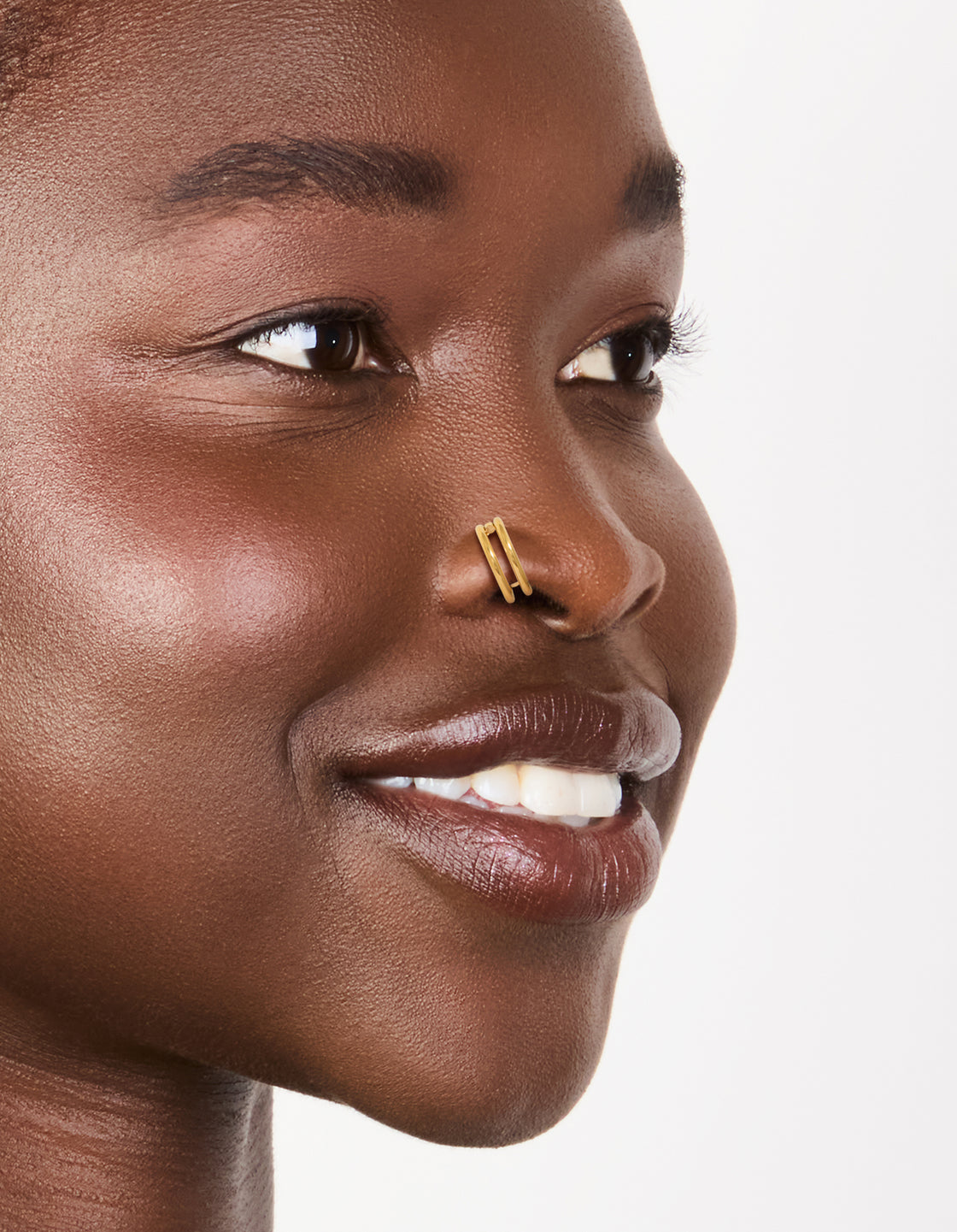 Showcasing gold plated surgical steel double hinged nose rings in a pack nose view