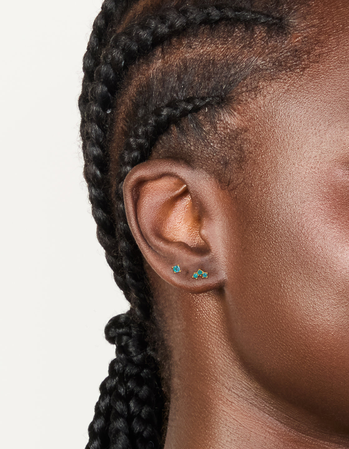 Featuring gold plated titanium blue cubic zirconia flat back studs with crystal details in light blue on ear view