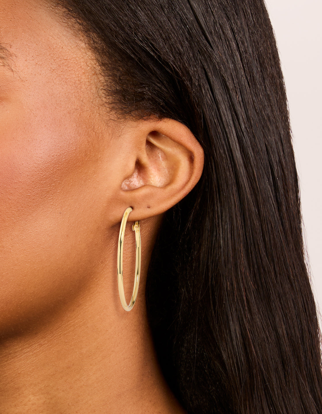 Crafted from gold plated material, small and medium hoop earrings 3-pack on ear view