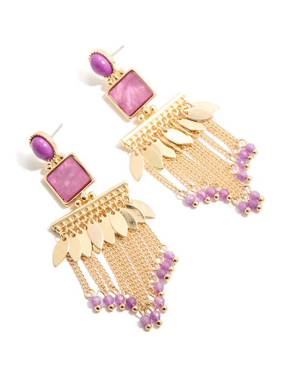 Showcasing statement drop earrings in gold with purple oval stones, leaf charms and beaded chain tassels in front view