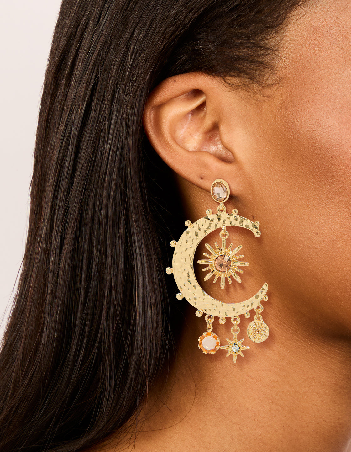 Stunning celestial charm drop earrings with moon featuring clear and pink diamante accents in gold on ear view