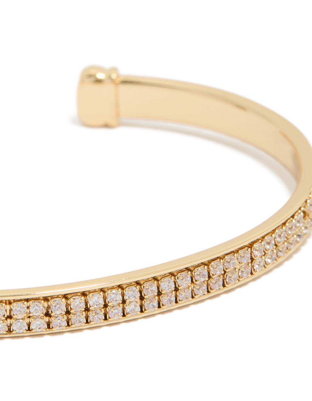 Highlighting a gold plated cubic zirconia flat bezel set wrist cuff close up view