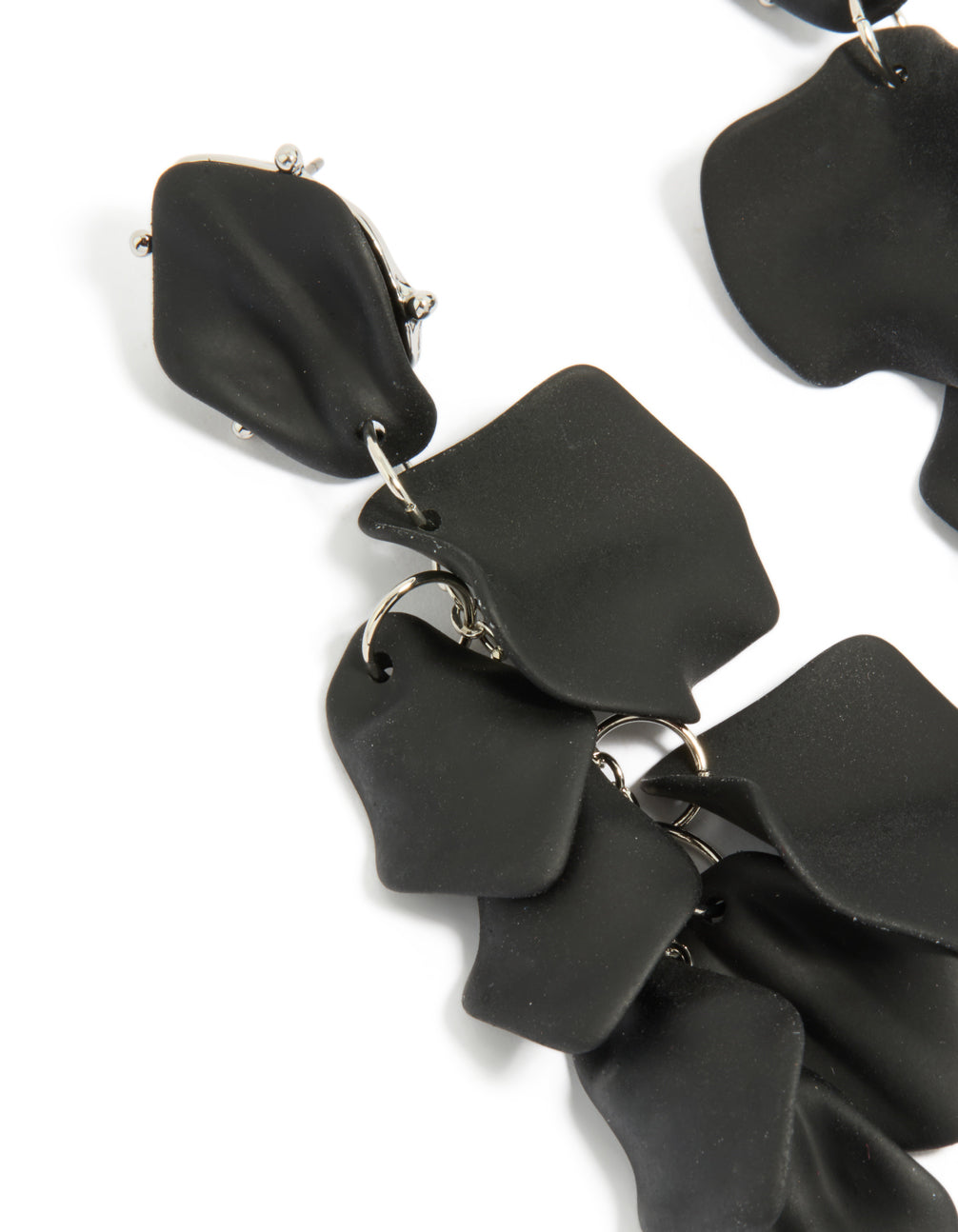 Featuring statement drop earrings with petal design in black coated metal featuring silver accents close up view