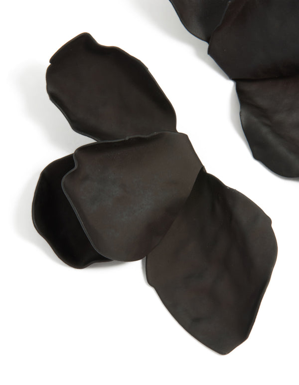 Featuring coated metal half flower petal drop earrings in black with statement style close up view