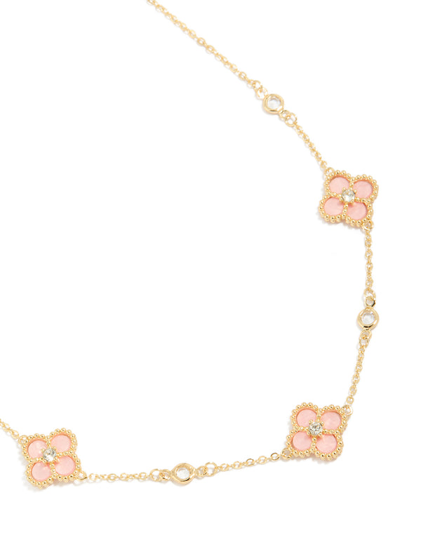 Showcasing a gold plated pink cubic zirconia flower trio necklace with dainty style front view