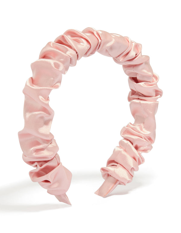 Showcasing a pink ruched satin headband in solid print front view