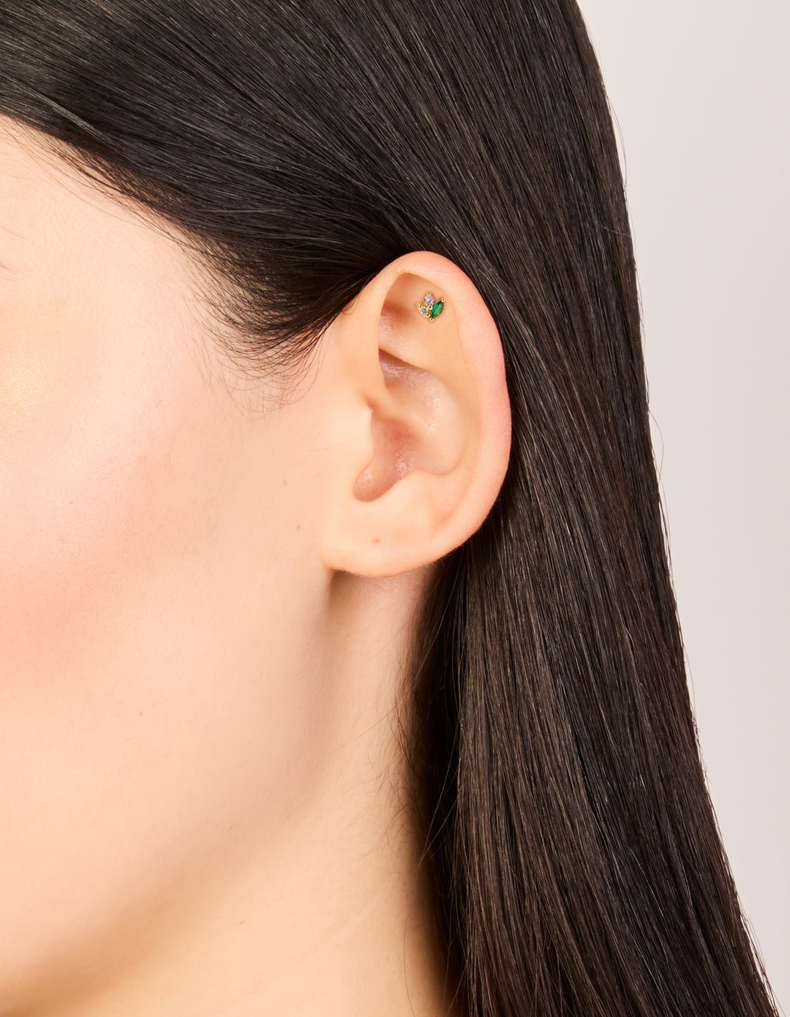 Showcasing a gold plated surgical steel green cubic zirconia cluster single flat back stud with pink and clear stones on ear view