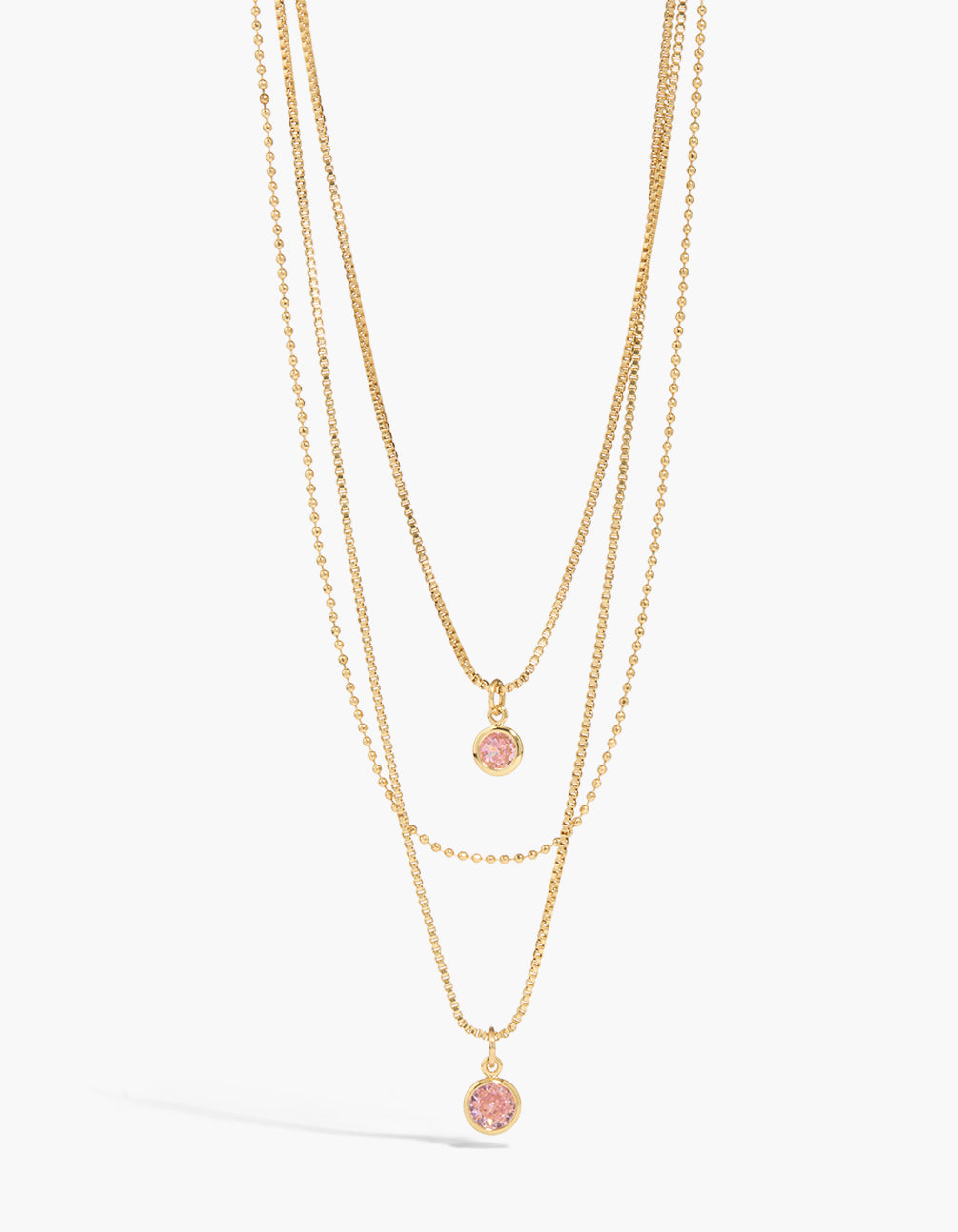 Showcasing a gold plated pink cubic zirconia layered necklace featuring pendant with crystal in statement style close up view