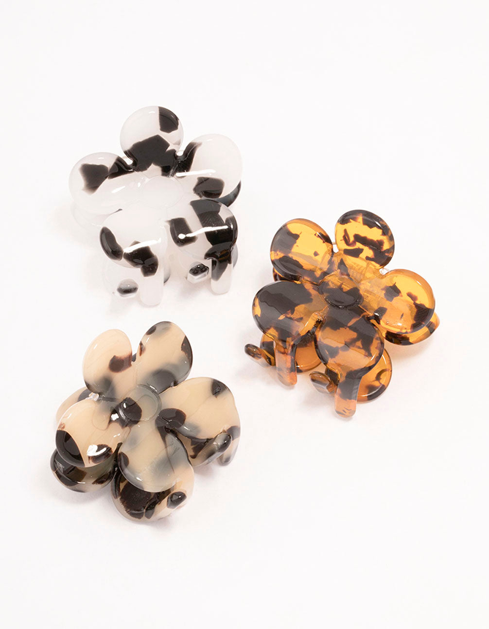 Discover small daisy hair claw clips in a 3-pack featuring floral design with tortoiseshell pattern in black, white, orange, and beige front view