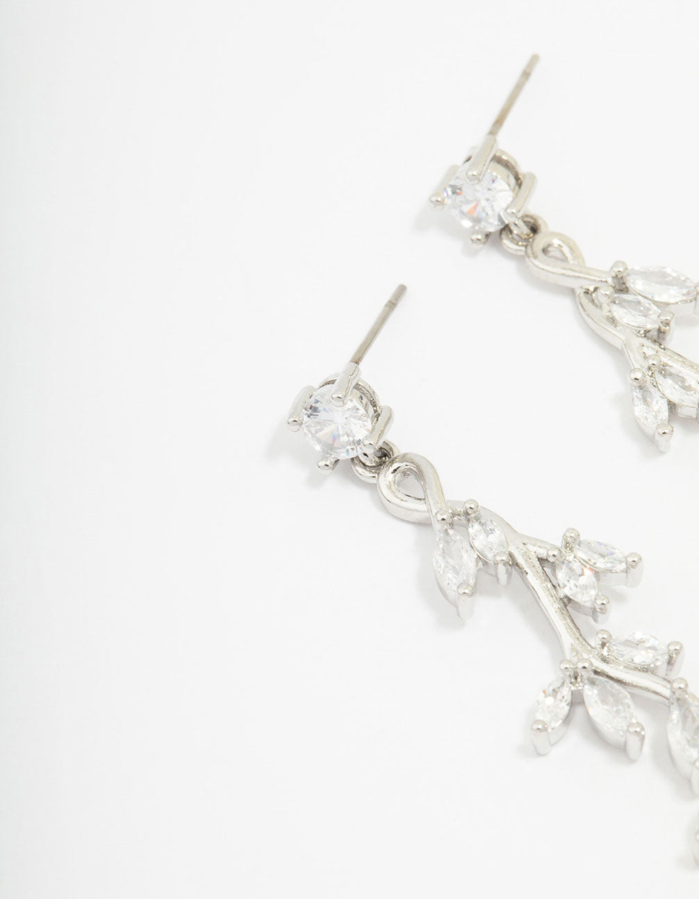 Featuring silver cubic zirconia vine leaf drop earrings with clear stones in a close up view
