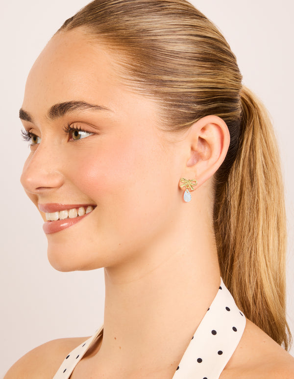 These statement bow earrings with pear cut crystal in gold plated sterling silver on model view