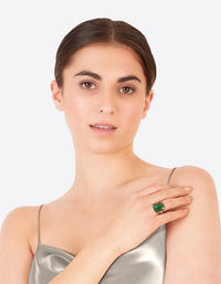 Featuring an emerald square cut stone on gold band with ornate prong setting on finger view - link has visual effect only