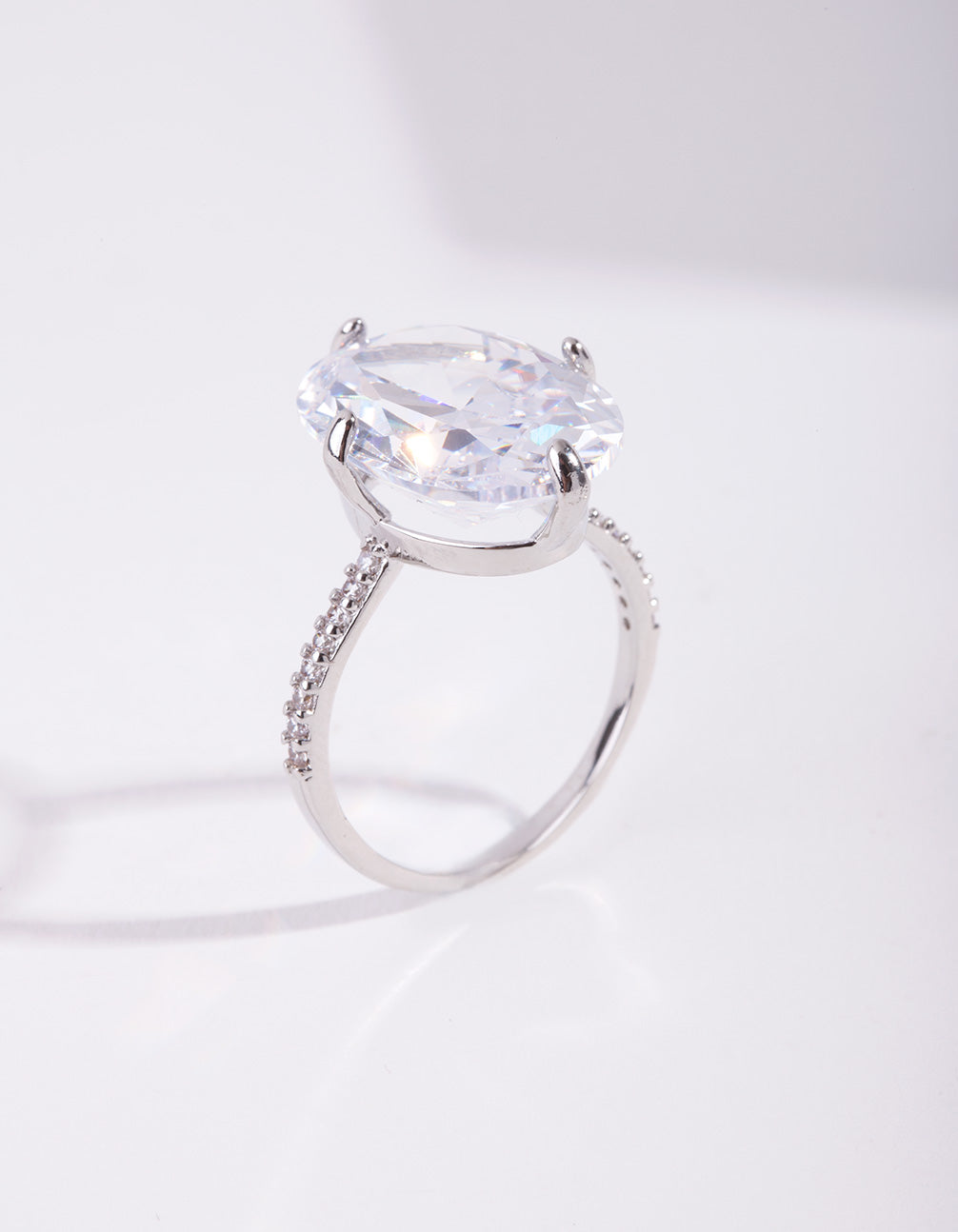 Showcasing a silver cubic zirconia large oval stone ring with crystal and statement design side detail view
