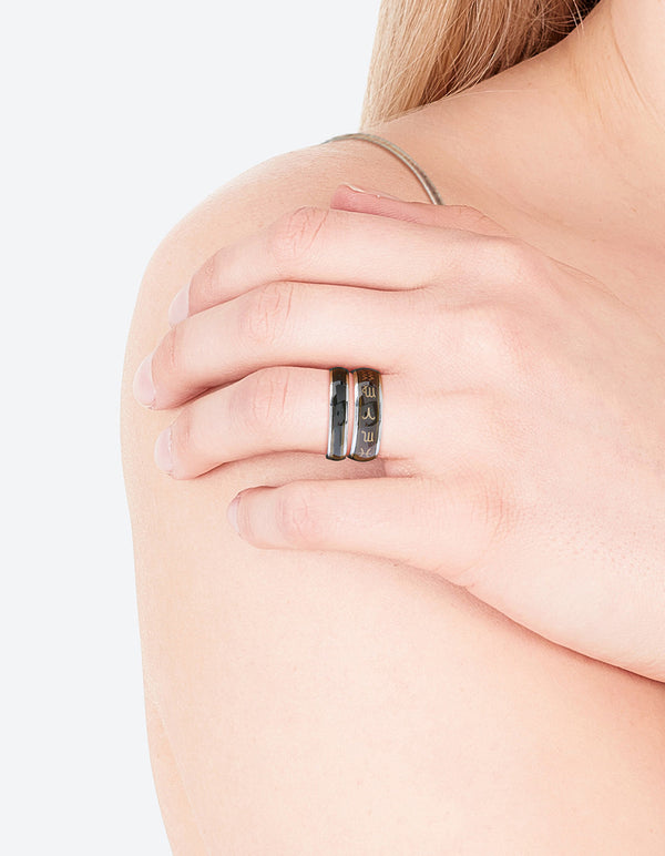 Featuring celestial silver symbol mood ring set with black and gold detailing on finger view