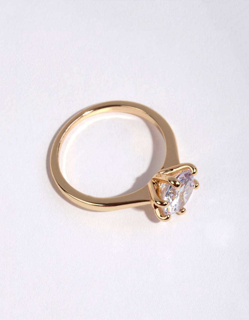 Crafted from gold plated material this round cubic zirconia ring highlights clear stone detailing side detail view