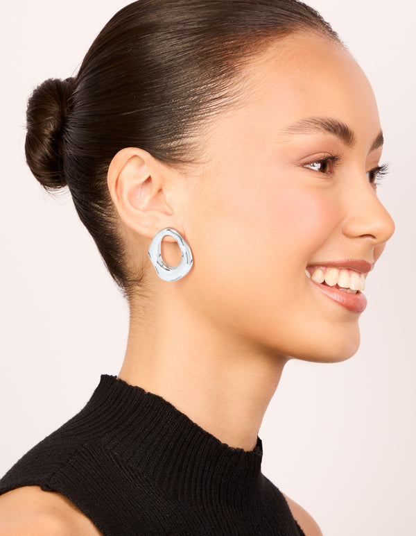 Showcasing molten open circle stud earrings crafted from silver plated metal on model view