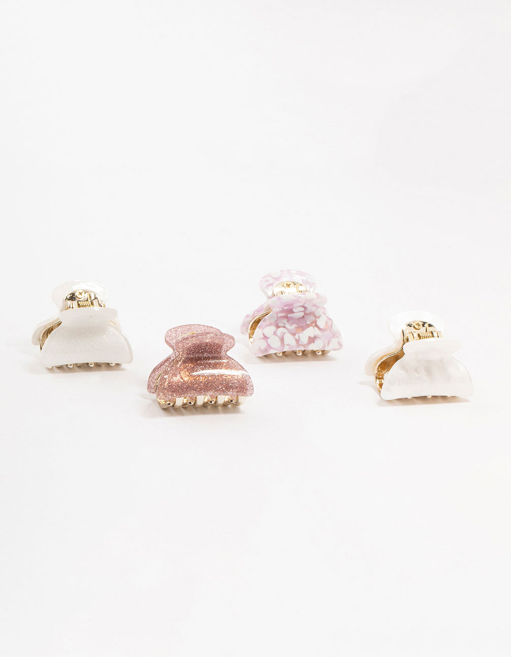 Discover acrylic claw clips featuring glitter in light pink, white, gold, and rosy brown front view