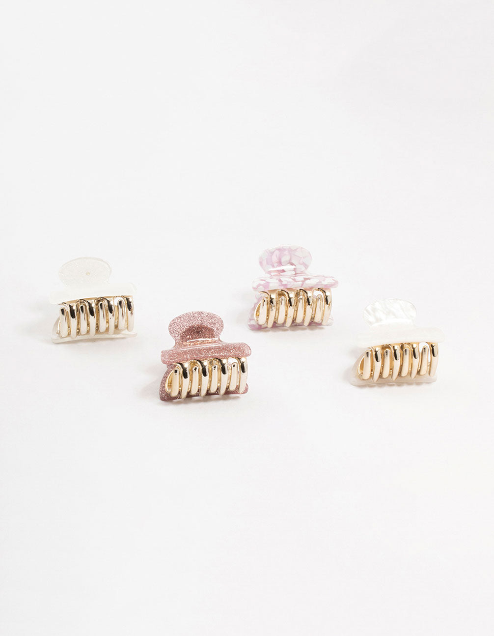 Elegant acrylic claw clips with glitter in light pink, white, gold, and rosy brown side view