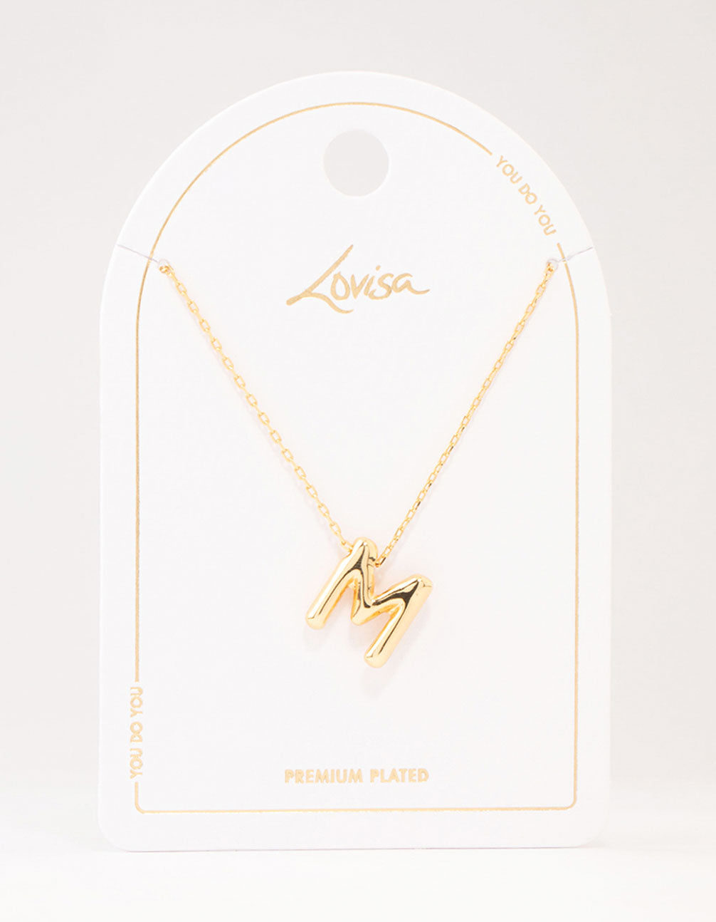 Showcasing a bubble letter M necklace with initials in gold plated finish close up view