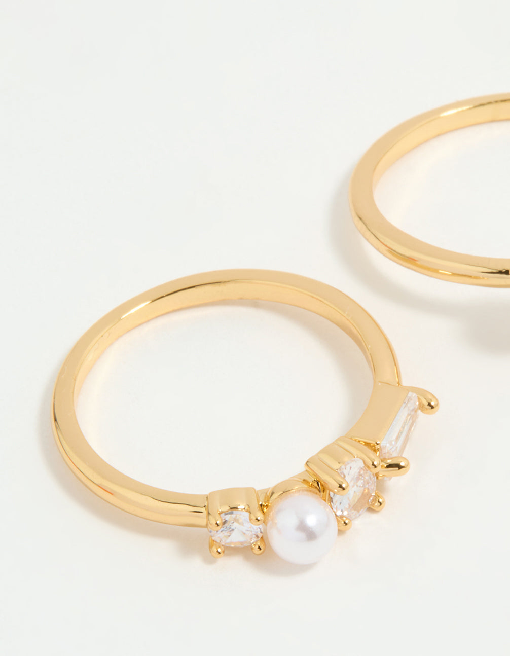 Showcasing gold plated cubic zirconia and pearl rings in a 3-pack close up view