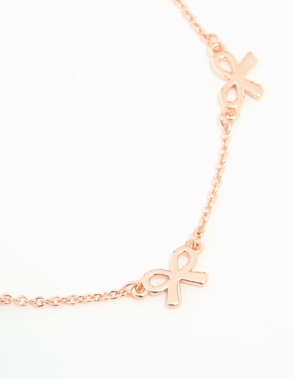 Beautifully crafted rose gold plated sterling silver bracelet featuring dainty bow charm accents close up view