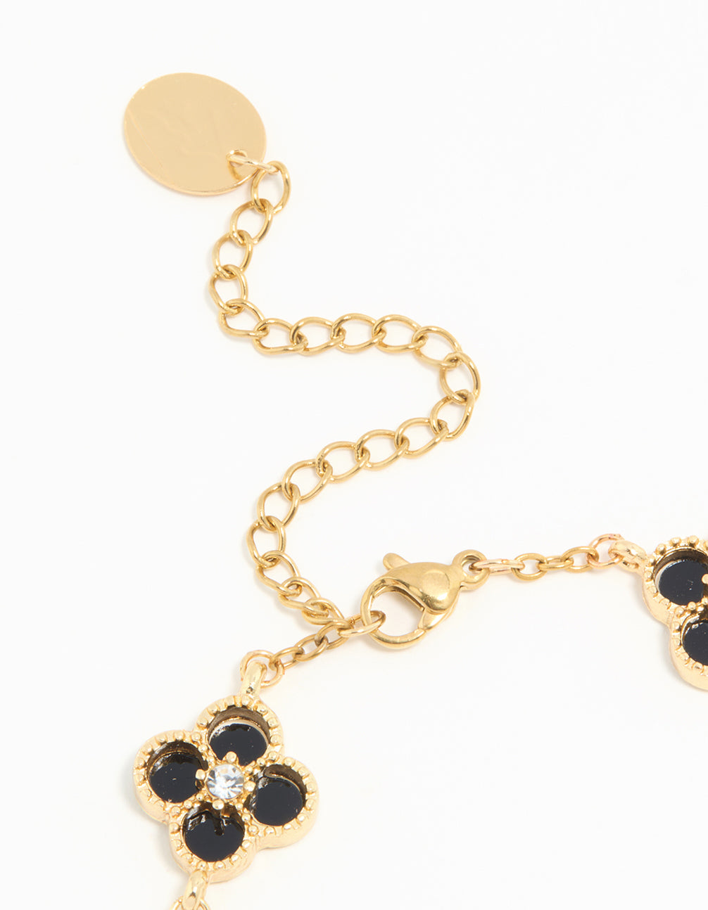 Highlighting the waterproof charm floral bracelet with gold plated stainless steel and diamante black inlay flowers closure detail view