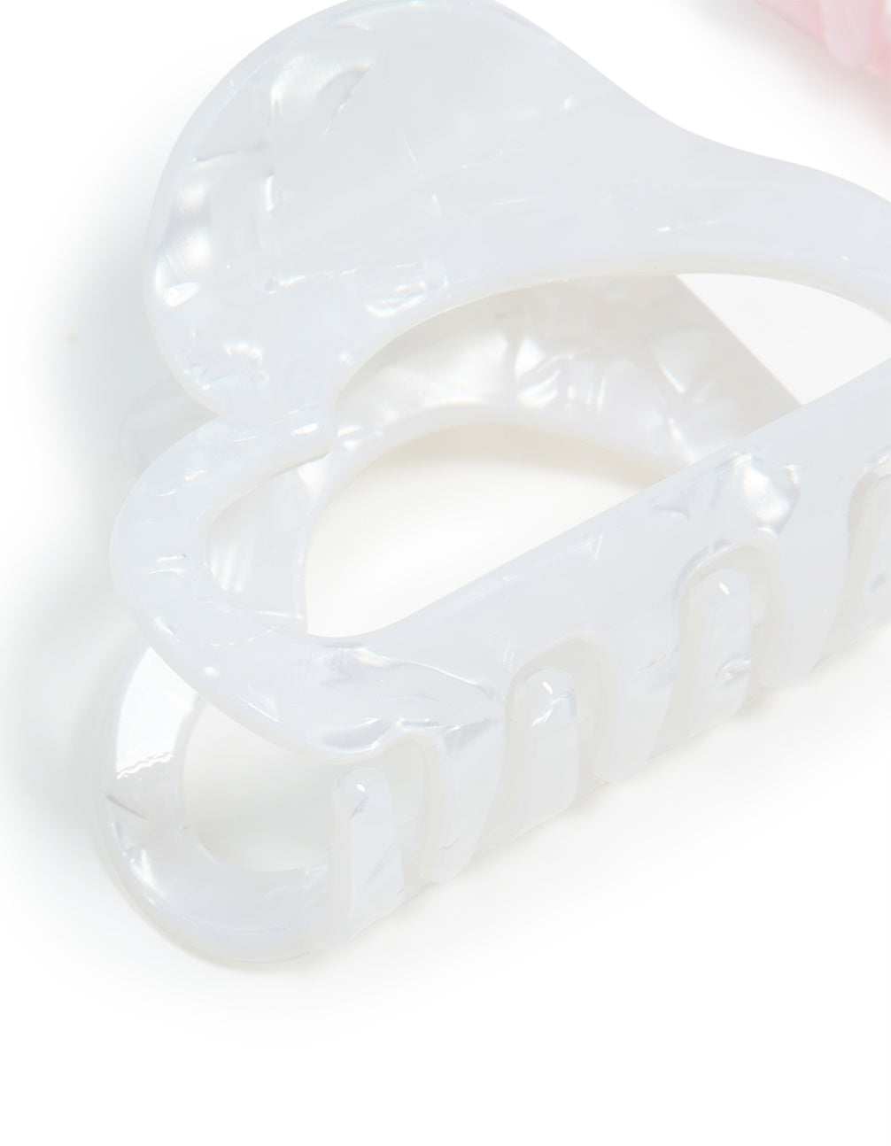 Showcasing heart shaped 2-pack pink and white acrylic small claw clips side view