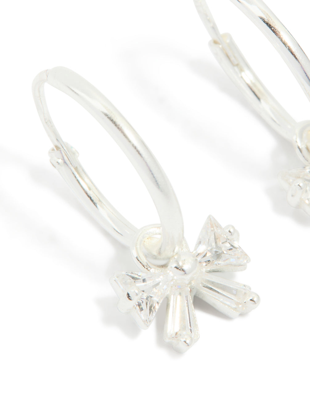 Detailed sterling silver cubic zirconia bow huggie earrings close up view