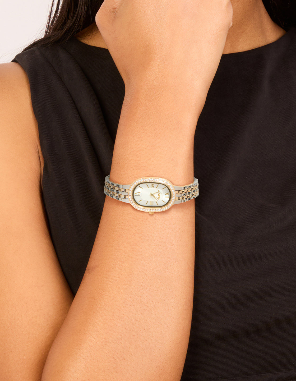Elegant mixed metals diamante medium oval watch with white dial featuring roman look, multi-color link band strap, formal occasion design crafted from gold and silver for women in analog type on wrist view