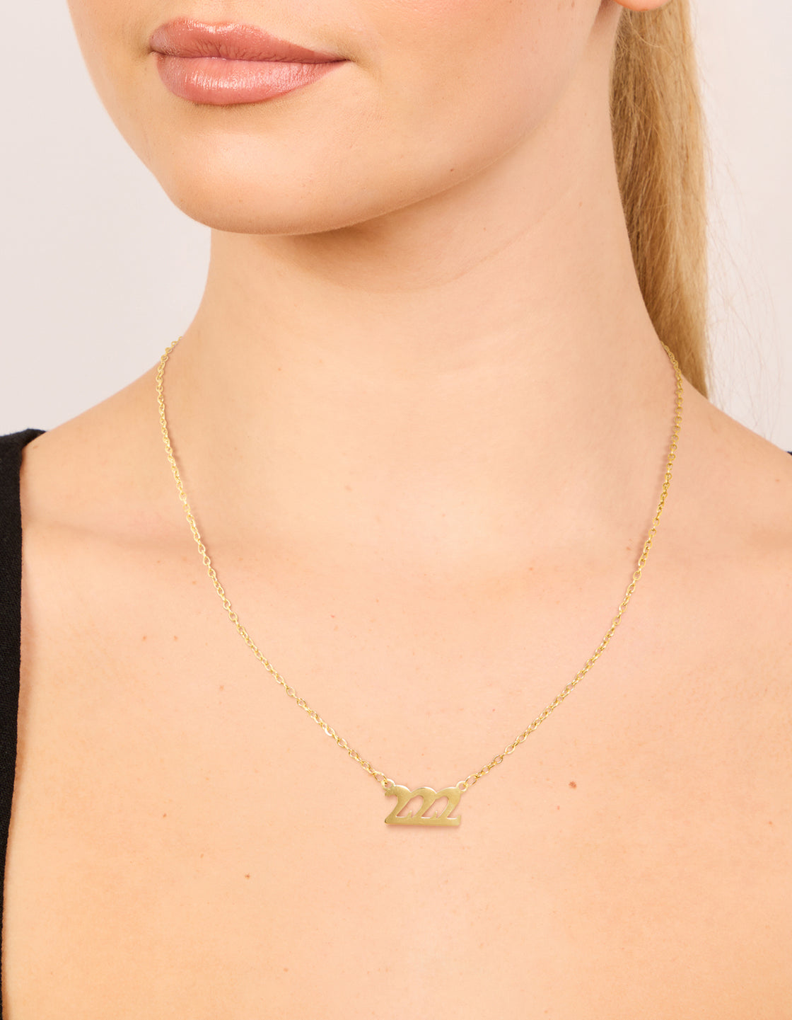 Featuring a waterproof gold plated stainless steel angel number 222 necklace on neck view