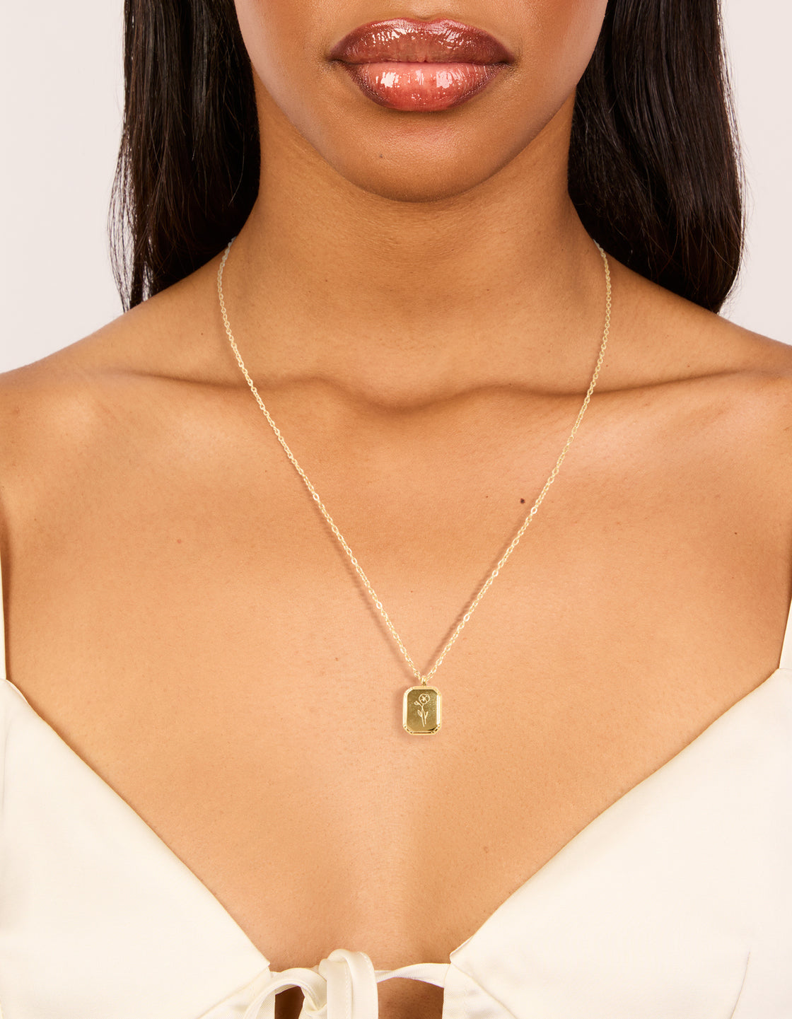 Featuring a waterproof gold plated stainless steel floral detail dainty February birth flower violet necklace on neck view