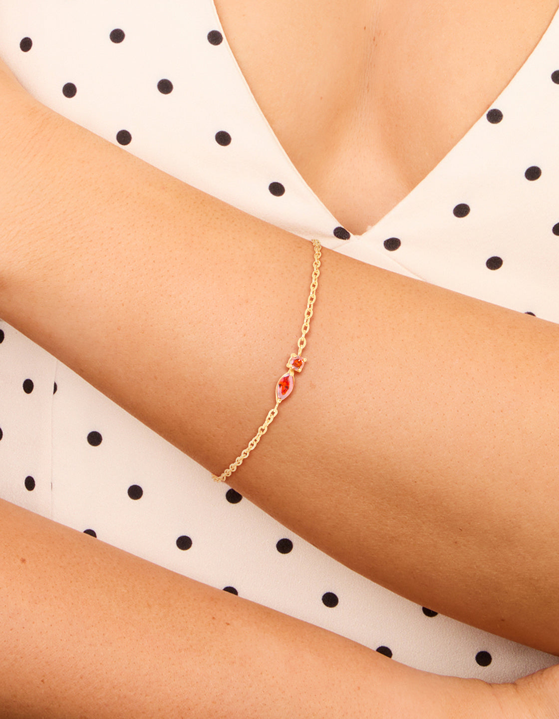 Crafted from waterproof stainless steel, this January birthstone bracelet features red cubic zirconia detailing in a dainty style, on wrist view