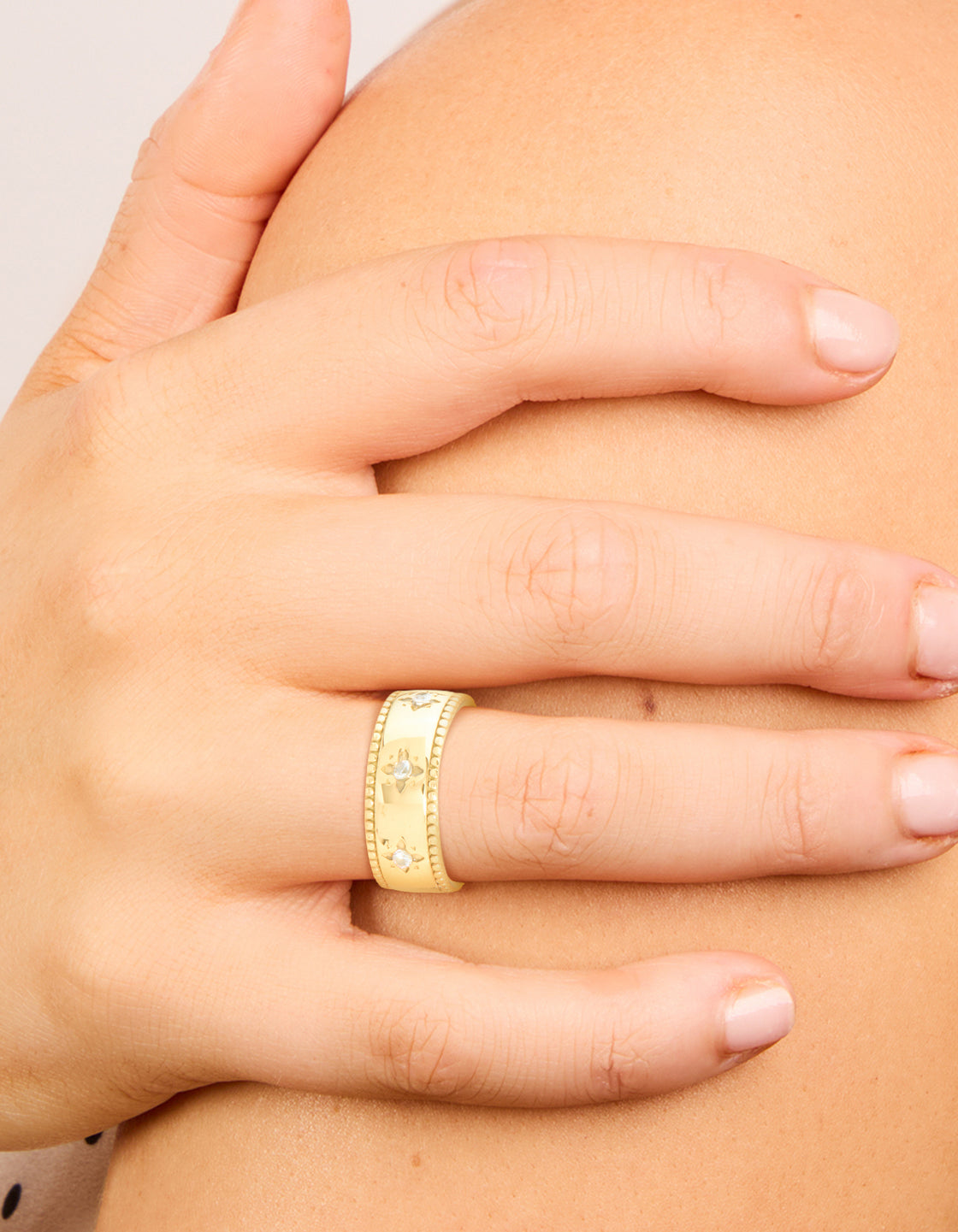 This waterproof gold plated stainless steel cubic zirconia star thick band ring with celestial feature on finger view